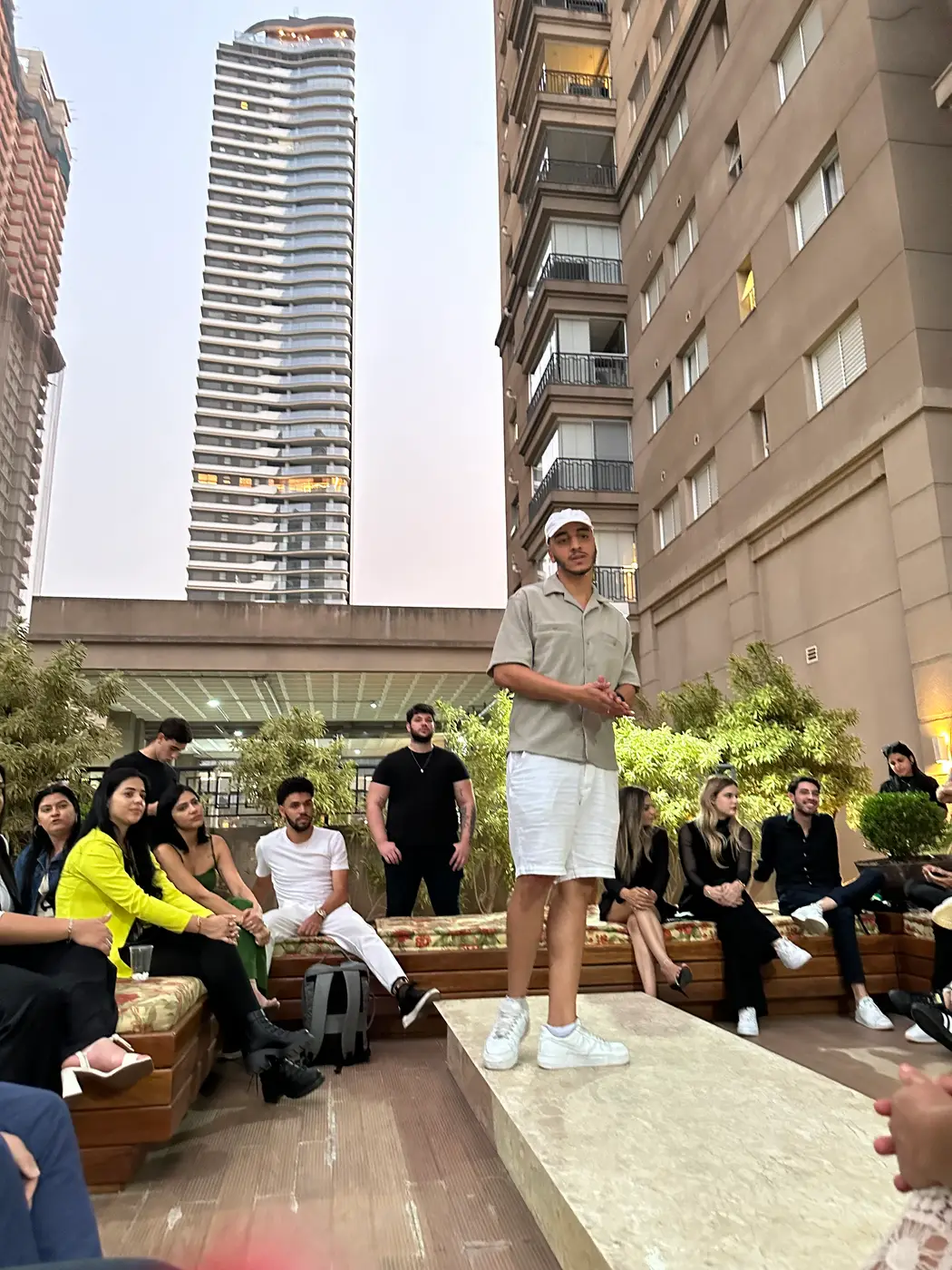 Thiago Máximo palestrando num terraço em São Paulo, com o público sentado em volta