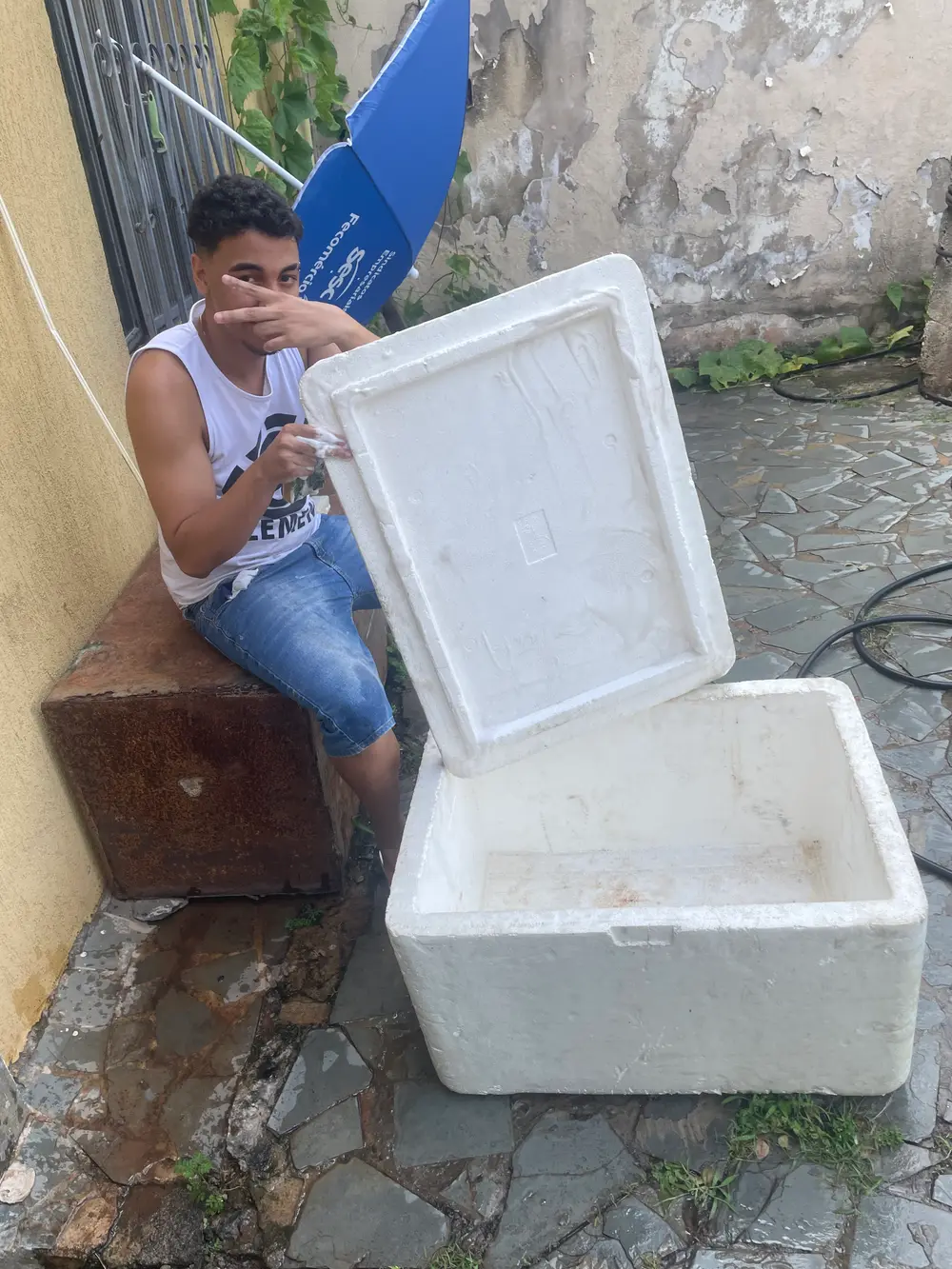 Thiago Máximo com o isopor que usava pra vender bebida na rua, em BH